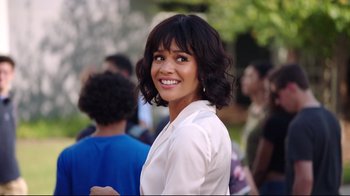 Movie still from “How High 2” (2019), directed by Bruce Leddy – A woman with brown curly hair smiling for the camera; Close Up shot, Over the shoulder angle