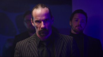 Movie still from “How High 2” (2019), directed by Bruce Leddy – A man in a suit and tie standing in front of two other men; Medium shot, Low angle