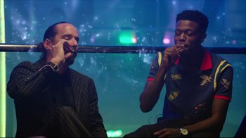 Movie still from “How High 2” (2019), directed by Bruce Leddy – Two men sitting next to each other in front of lights; Medium shot, Low angle