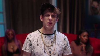 Movie still from “How High 2” (2019), directed by Bruce Leddy – A young man wearing a hat and a chain necklace; Close Up shot, Over the shoulder angle