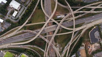 Movie still from “How High 2” (2019), directed by Bruce Leddy – An aerial view of a highway with many lanes and lots of traffic on it; Extreme Wide shot, Overhead angle