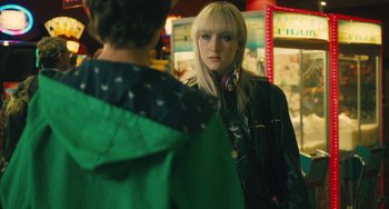 Movie still from “How I Live Now” (2013), directed by Kevin Macdonald – A woman wearing headphones and a jacket looking at a man; Close Up shot, Over the shoulder angle