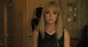 Movie still from “How I Live Now” (2013), directed by Kevin Macdonald – A woman with blonde long hair wearing a black top; Close Up shot, Over the shoulder angle