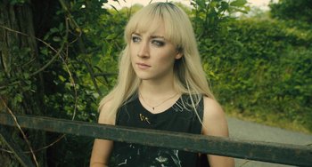 Movie still from “How I Live Now” (2013), directed by Kevin Macdonald – A woman with blonde hair and a black shirt; Close Up shot, High angle