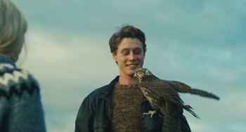 Movie still from “How I Live Now” (2013), directed by Kevin Macdonald – A man holding a bird on his shoulder; Close Up shot, Low angle