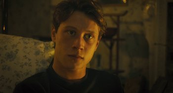 Movie still from “How I Live Now” (2013), directed by Kevin Macdonald – A young man is looking into the camera; Close Up shot, Low angle