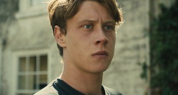 Movie still from “How I Live Now” (2013), directed by Kevin Macdonald – A person with short brown hair; Close Up shot, Low angle