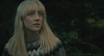 Movie still from “How I Live Now” (2013), directed by Kevin Macdonald – A woman with blonde hair wearing a sweater looking to her left; Close Up shot, Low angle