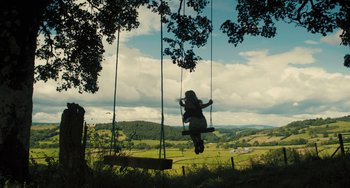 Movie still from “How I Live Now” (2013), directed by Kevin Macdonald – A woman is swinging on a swing set; Extreme Wide shot, High angle