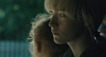 Movie still from “How I Live Now” (2013), directed by Kevin Macdonald – A person's face in a dark room; Close Up shot, Over the shoulder angle