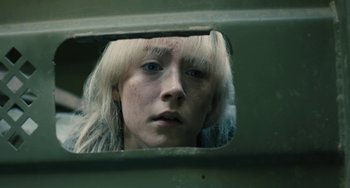 Movie still from “How I Live Now” (2013), directed by Kevin Macdonald – A woman with blonde hair looking out a window; Close Up shot, Low angle