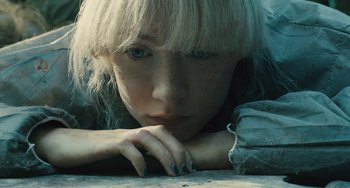 Movie still from “How I Live Now” (2013), directed by Kevin Macdonald – A woman with blonde hair is leaning on the ground; Close Up shot, High angle
