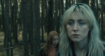 Movie still from “How I Live Now” (2013), directed by Kevin Macdonald – A woman and a child in a forest; Close Up shot, Over the shoulder angle
