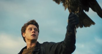 Movie still from “How I Live Now” (2013), directed by Kevin Macdonald – A man holding a bird in his hand; Close Up shot, Low angle