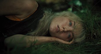 Movie still from “How I Live Now” (2013), directed by Kevin Macdonald – A woman laying in the grass with her head resting on her hand; Close Up shot, High angle
