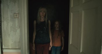 Movie still from “How I Live Now” (2013), directed by Kevin Macdonald – A woman and a girl standing in a doorway; Medium shot, High angle