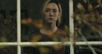 Movie still from “How I Live Now” (2013), directed by Kevin Macdonald – A woman looking out of a window at the leaves; Close Up shot, Over the shoulder angle
