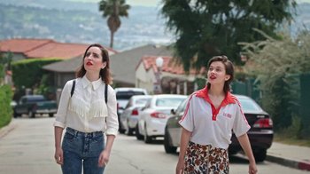 Movie still from “How It Ends” (2021), directed by Daryl Wein – Two women walking down a street near some parked cars; Medium shot, Over the shoulder angle