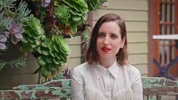 Movie still from “How It Ends” (2021), directed by Daryl Wein – A woman with red lipstick sitting in front of a plant; Close Up shot, High angle