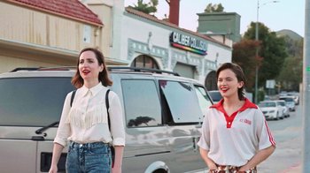 Movie still from “How It Ends” (2021), directed by Daryl Wein – Two young women walking down the street in front of a van; Medium shot, Low angle