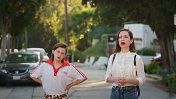 Movie still from “How It Ends” (2021), directed by Daryl Wein – Two young women standing on the side of the street; Medium shot, High angle