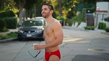 Movie still from “How It Ends” (2021), directed by Daryl Wein – A man in a red swim trunks is walking down the street; Medium shot, Over the shoulder angle