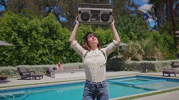 Movie still from “How It Ends” (2021), directed by Daryl Wein – A woman holding up a boombox above her head; Medium shot, Low angle