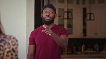 Movie still from “How It Ends” (2021), directed by Daryl Wein – A man in a red shirt and a black hat; Medium shot, Over the shoulder angle