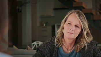 Movie still from “How It Ends” (2021), directed by Daryl Wein – A person sitting on a couch; Close Up shot, Over the shoulder angle