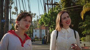 Movie still from “How It Ends” (2021), directed by Daryl Wein – Two young women standing next to each other on the street; Close Up shot, Over the shoulder angle