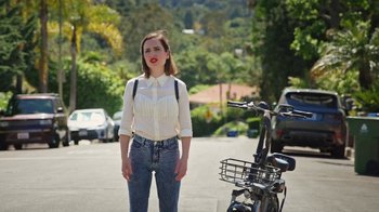 Movie still from “How It Ends” (2021), directed by Daryl Wein – A woman standing in front of a bicycle; Medium shot, Over the shoulder angle