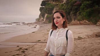 Movie still from “How It Ends” (2021), directed by Daryl Wein – A woman standing on the beach in front of a cliff; Close Up shot, High angle