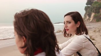 Movie still from “How It Ends” (2021), directed by Daryl Wein – A woman sitting next to another woman on a beach; Close Up shot, Over the shoulder angle
