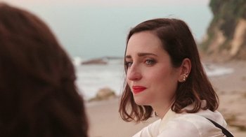 Movie still from “How It Ends” (2021), directed by Daryl Wein – A person sitting on the beach; Close Up shot, Over the shoulder angle