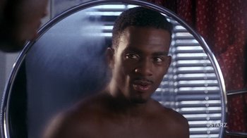 Movie still from “How to Be a Player” (1997), directed by Lionel C. Martin – A shirtless man in front of a bathroom mirror; Close Up shot, Over the shoulder angle