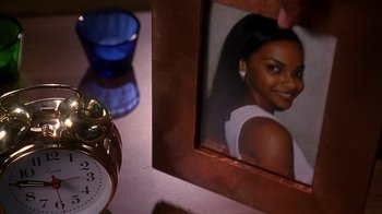 Movie still from “How to Be a Player” (1997), directed by Lionel C. Martin – A picture of a young woman in a picture frame next to an alarm clock; Extreme Close Up shot, High angle