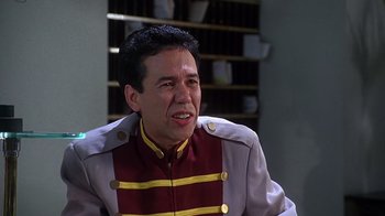 Movie still from “How to Be a Player” (1997), directed by Lionel C. Martin – A man in a uniform is sitting in a room; Close Up shot, Over the shoulder angle