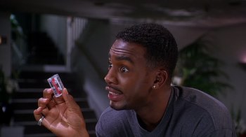 Movie still from “How to Be a Player” (1997), directed by Lionel C. Martin – A young man holding up a cell phone to his face; Close Up shot, High angle