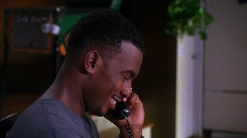 Movie still from “How to Be a Player” (1997), directed by Lionel C. Martin – A man talking on a cell phone while smiling; Close Up shot, High angle
