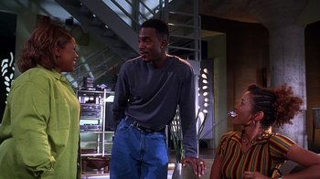 Movie still from “How to Be a Player” (1997), directed by Lionel C. Martin – A group of people standing in a living room talking; Medium shot, Over the shoulder angle