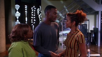 Movie still from “How to Be a Player” (1997), directed by Lionel C. Martin – A group of people standing next to each other in a room; Medium shot, Over the shoulder angle