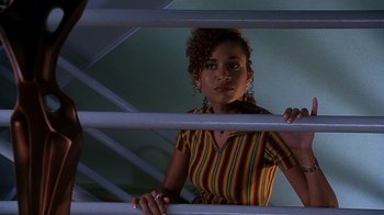 Movie still from “How to Be a Player” (1997), directed by Lionel C. Martin – A woman standing on top of a metal railing; Medium shot, Low angle