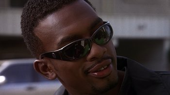 Movie still from “How to Be a Player” (1997), directed by Lionel C. Martin – A person wearing a pair of sunglasses; Close Up shot, Low angle