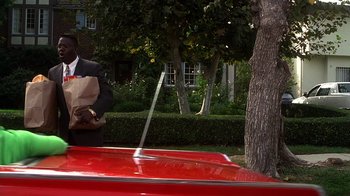 Movie still from “How to Be a Player” (1997), directed by Lionel C. Martin – A man standing on the hood of a red car; Medium shot, Over the shoulder angle