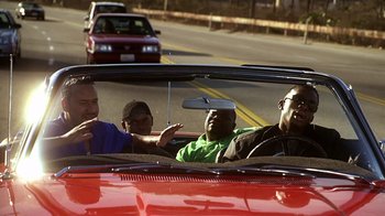 Movie still from “How to Be a Player” (1997), directed by Lionel C. Martin – A group of men riding in the back of a red car; Medium shot, Over the shoulder angle