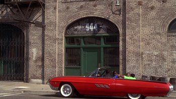 Movie still from “How to Be a Player” (1997), directed by Lionel C. Martin – Two people in a red car in front of a brick building; Wide shot, High angle