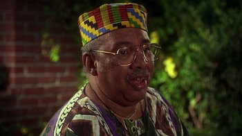 Movie still from “How to Be a Player” (1997), directed by Lionel C. Martin – An older man wearing a multicolored hat and glasses; Close Up shot, Low angle