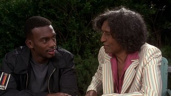 Movie still from “How to Be a Player” (1997), directed by Lionel C. Martin – Two men sitting at a table talking to each other; Medium shot, Over the shoulder angle