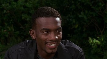 Movie still from “How to Be a Player” (1997), directed by Lionel C. Martin – A person smiling with trees in the background; Close Up shot, High angle