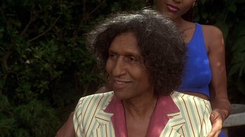 Movie still from “How to Be a Player” (1997), directed by Lionel C. Martin – An older man with a curly hair and a pink and white striped jacket; Close Up shot, High angle